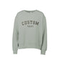 A greenstone crewneck sweatshirt with 'CUSTOM TEXT' embroidered in a dark brown arched font on the chest, displayed against a solid white background.