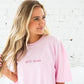 woman wearing a blossom comfort colors tee with custom mama embroidered design in a pink thread