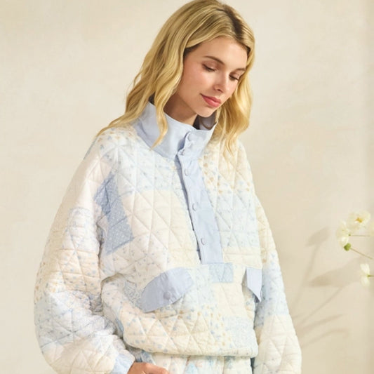 Woman wearing a floral quilted pullover jacket with a neutral background