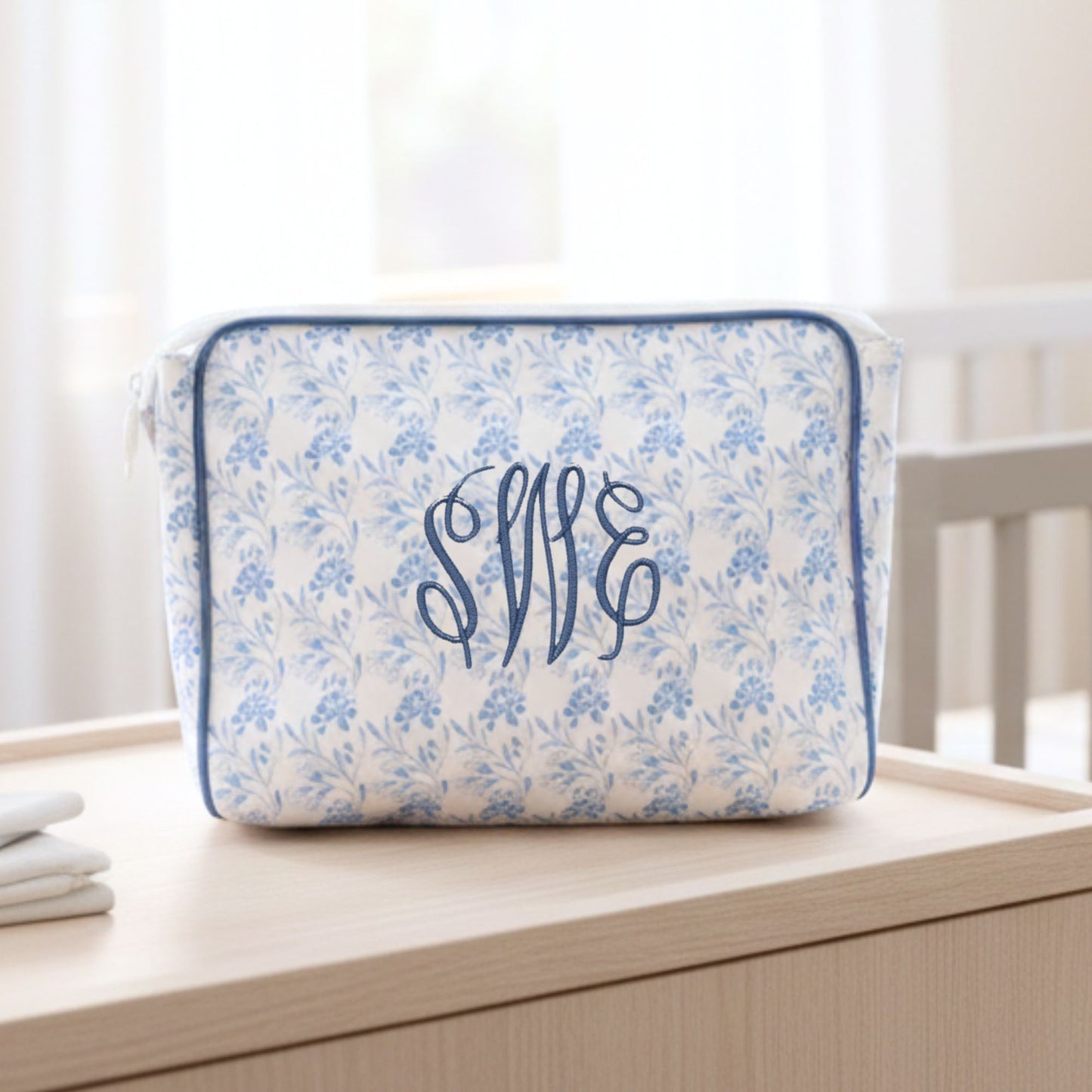 Floral pouch with monogram on a wooden surface
