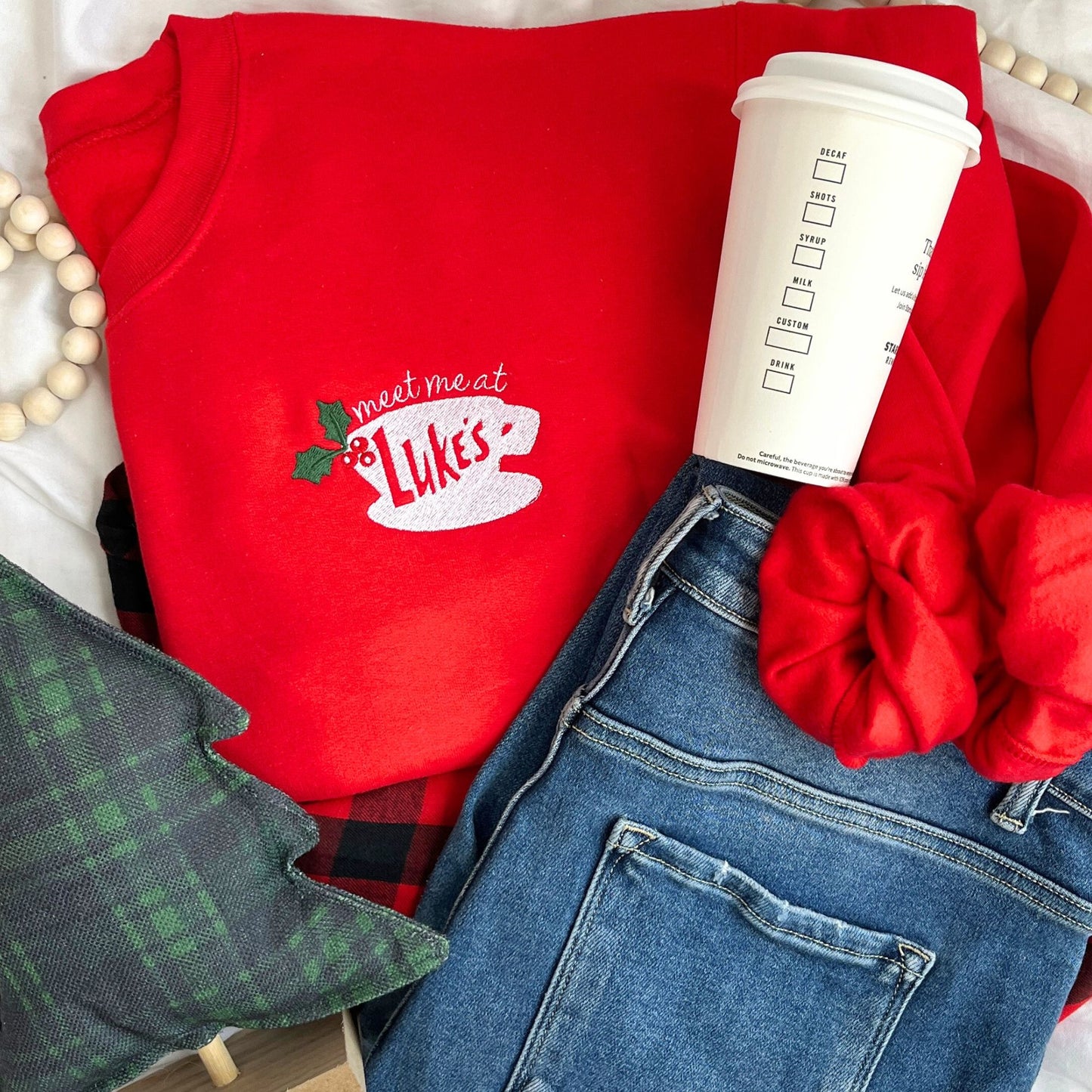 red crewneck sweatshirt with custom embroidered "meet me at Luke's" coffee cup holly design on the left chest