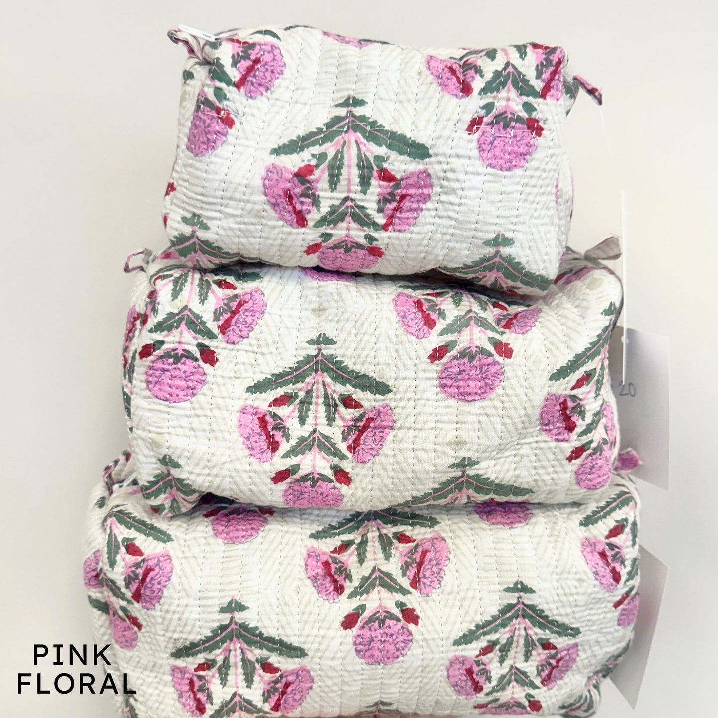 Stack of pink floral-patterned bags on a white background