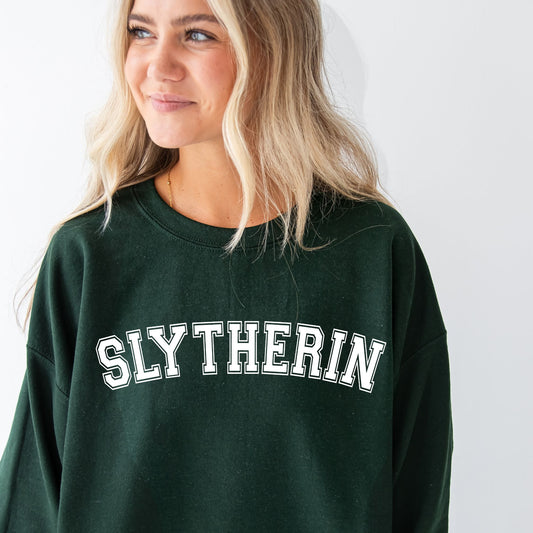 girl wearing an oversized forest green crewneck sweatshirt with a custom slytherin dtf print in white