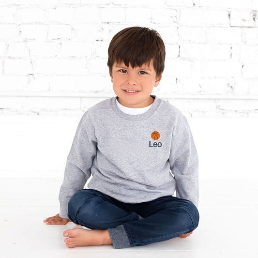 little boy wearing a heather pullover crewneck with custom name and mini basketball embroidered design on the left chest