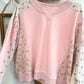 Pink sweatshirt with floral sleeves on a light background