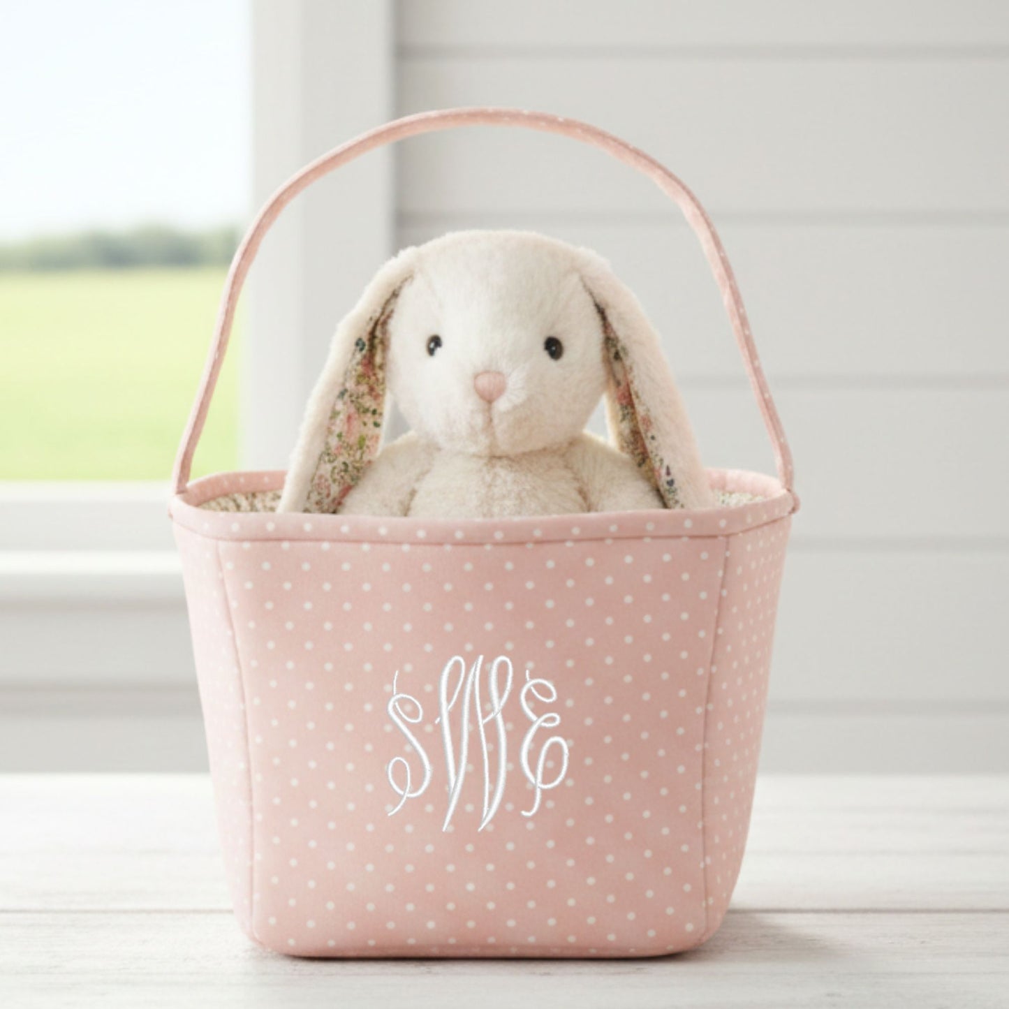 pink polka dot fabric basket with custom monogram embroidered in a white thread and a bunny inside