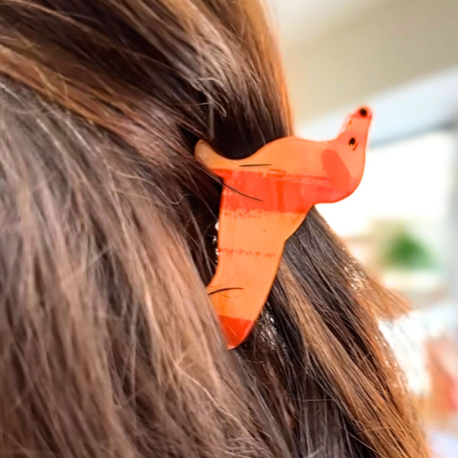 Orange Dachshund hair clip in a person's hair 