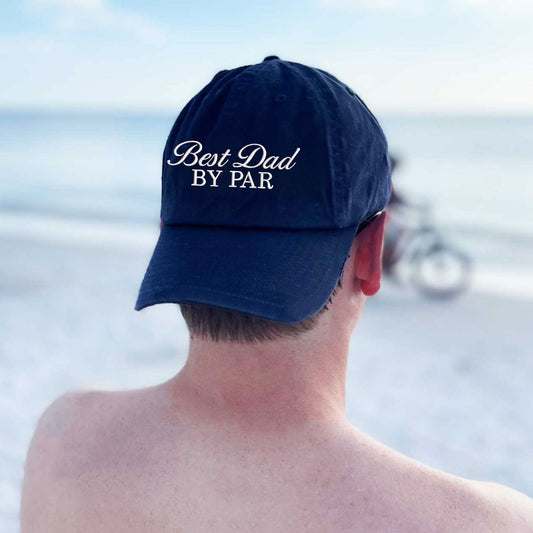 man wearing a navy baseball cap with embroidered best dad by par design in natural thread