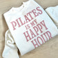 White sweatshirt with pink text 'PILATES IS MY HAPPY HOUR' on a wooden surface