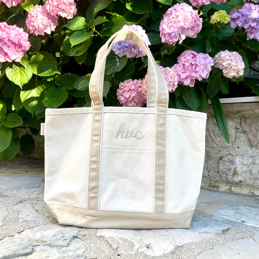 medium boat tote with safari trim with font 5 embroidered monogram, a script font, embroidered above the front pocket in camel thread