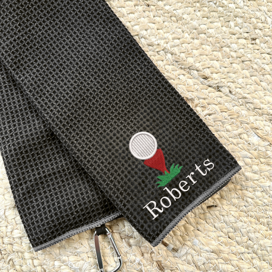 Deep Smoke tri-fold waffle microfiber golf towel with carabiner and custom golf ball/tee and Schoolbook font custom text in white thread embroidered design