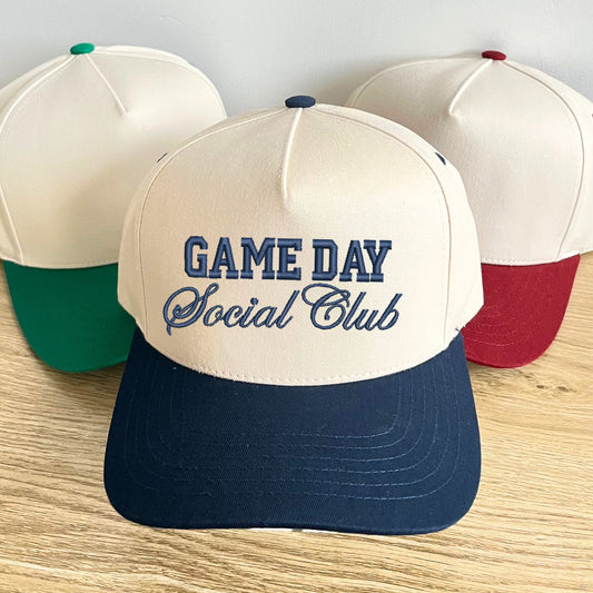 group of green, burgundy, and navy canvas two toned trucker hat with custom game day social club embroidery