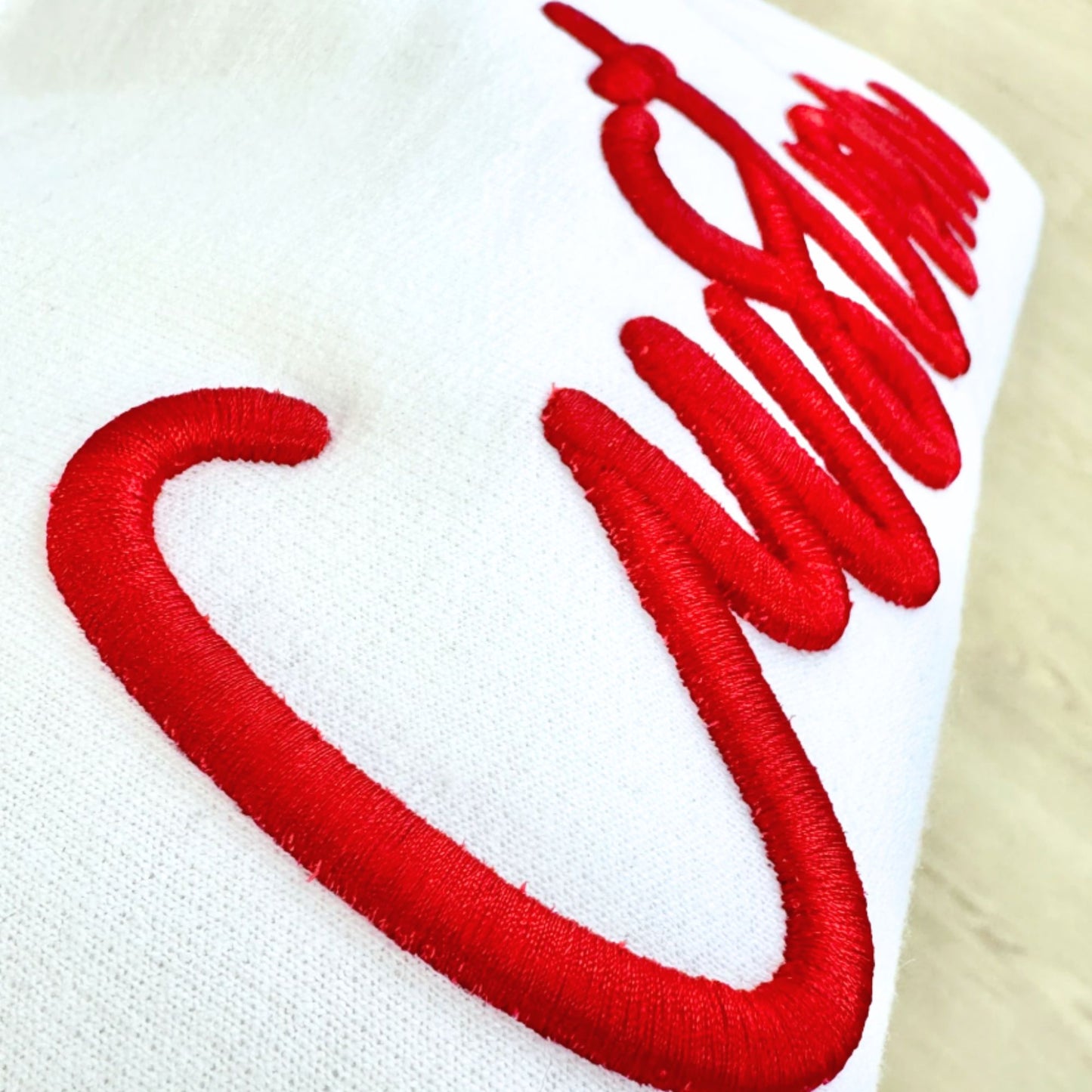 Red embroidered design on a white fabric background