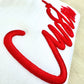 Red embroidered design on a white fabric background