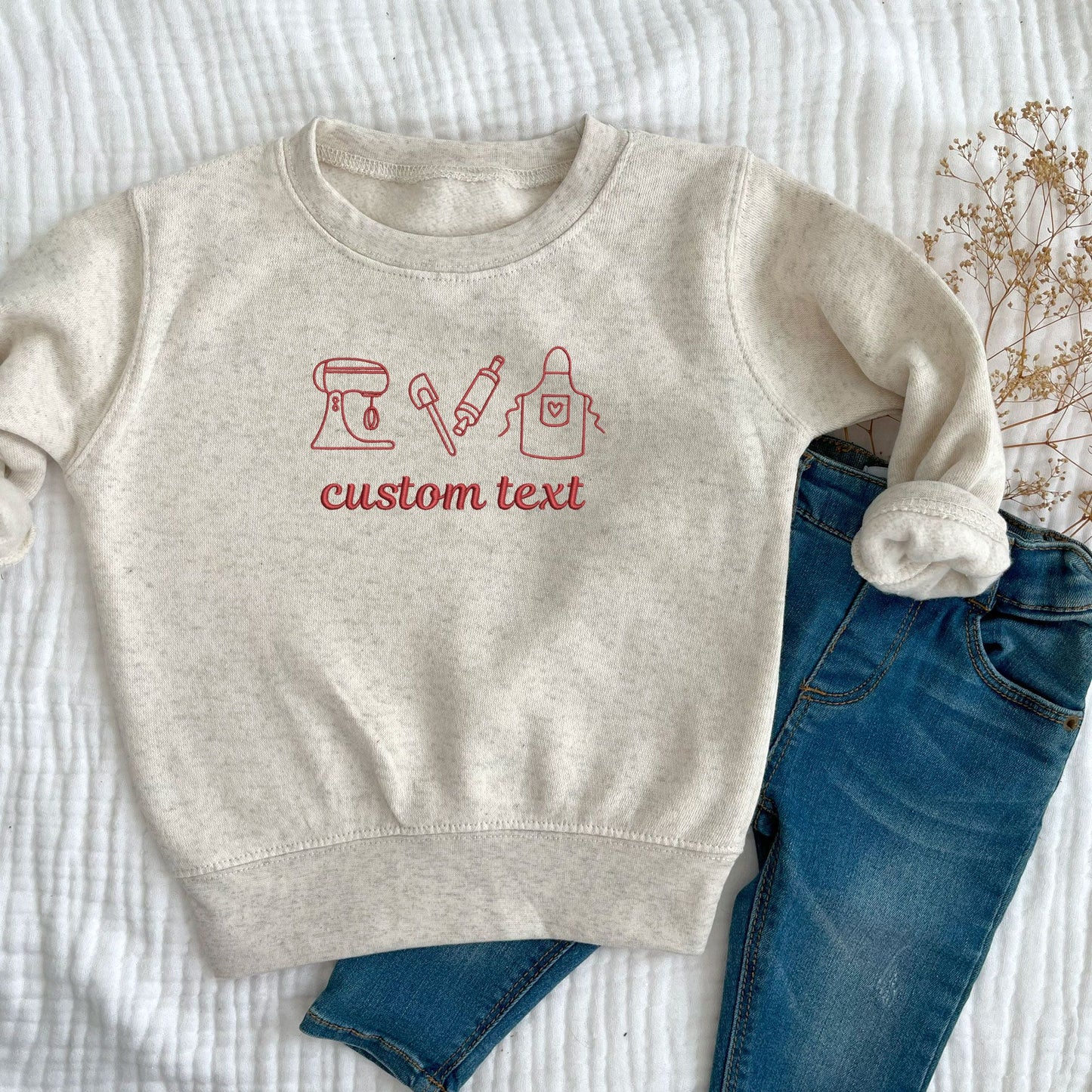 toddler heather oatmeal crewneck sweatshirt with embroidered baking icons and custom text in red thread