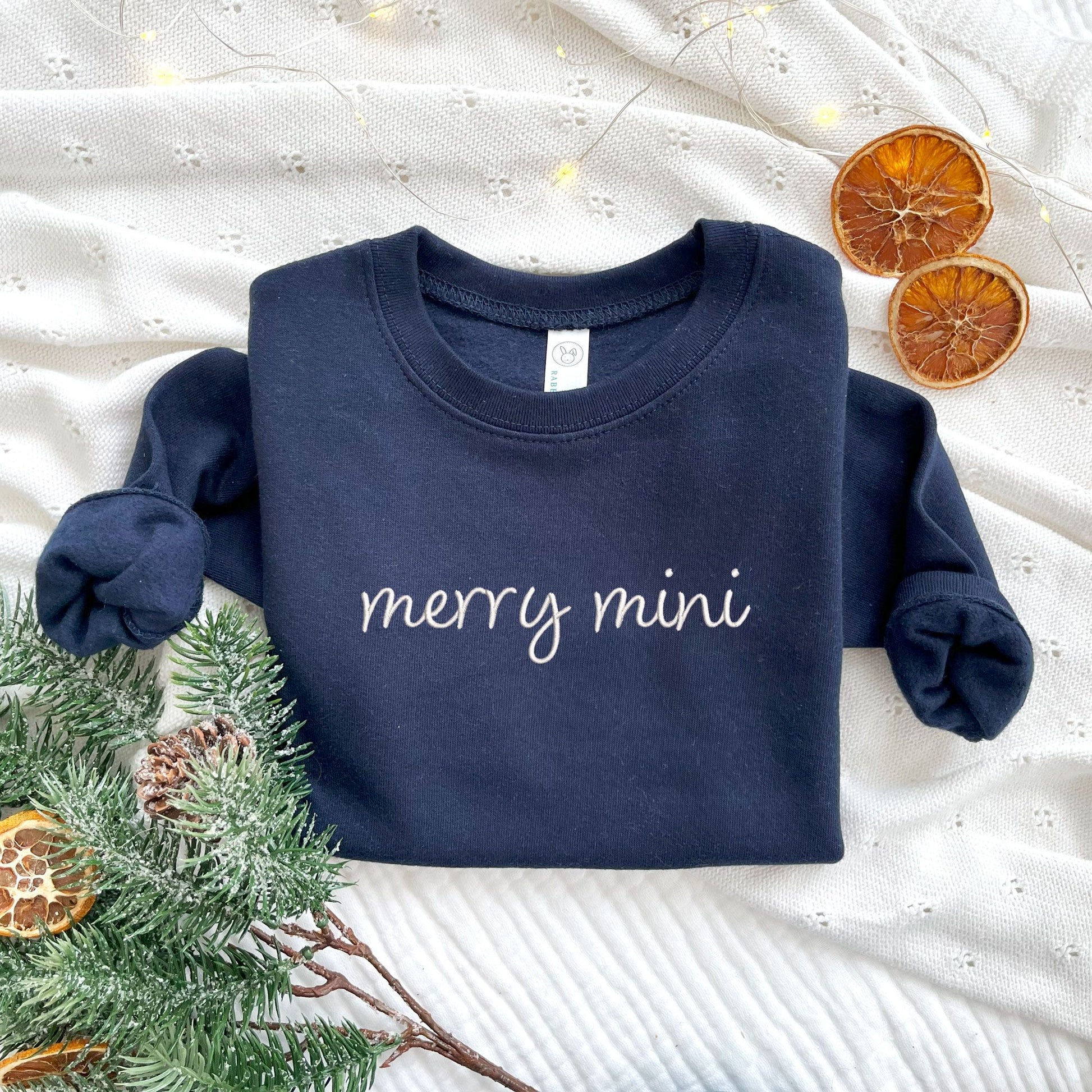 toddler navy crewneck sweatshirt with embroidered merry mini design in white thread across the chest