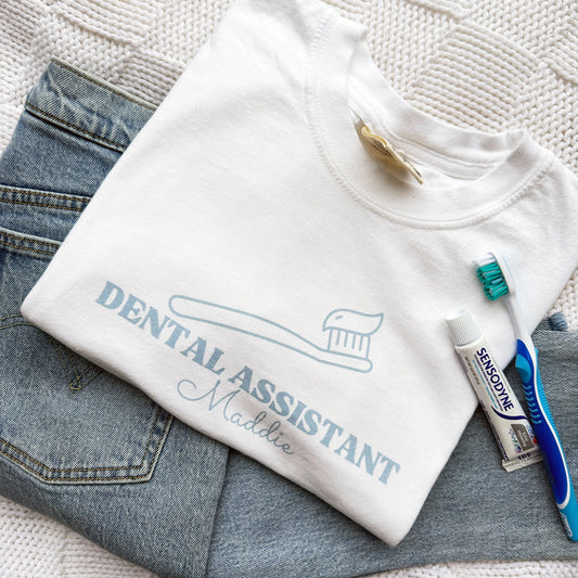 white comfort colors tee with a dental assistant printed design on the front