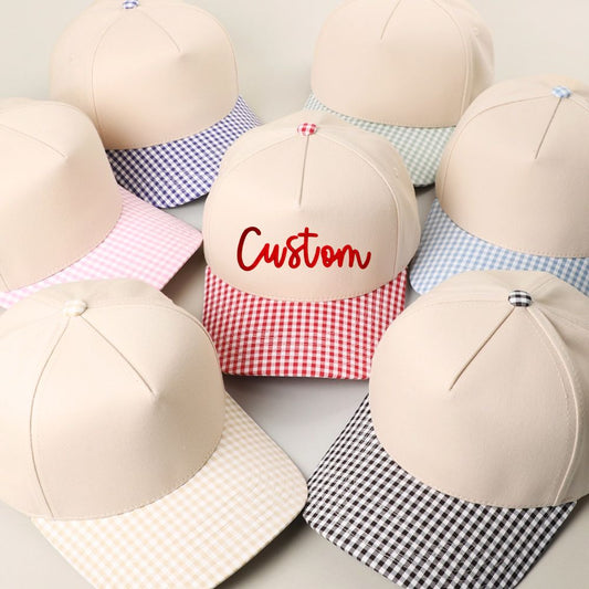 Beige baseball caps with gingham visors on a light background