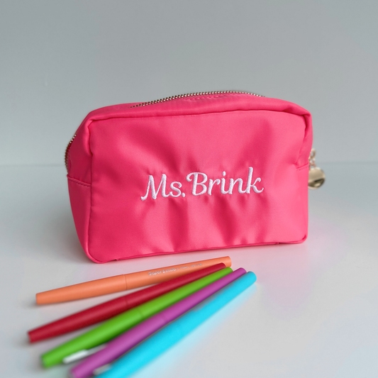 a hot pink pencil pouch with custom teacher name embroidery