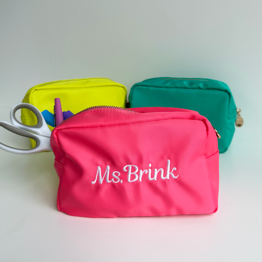 a neon yellow, turquoise, and hot pink nylon pencil pouch with custom name embroidery