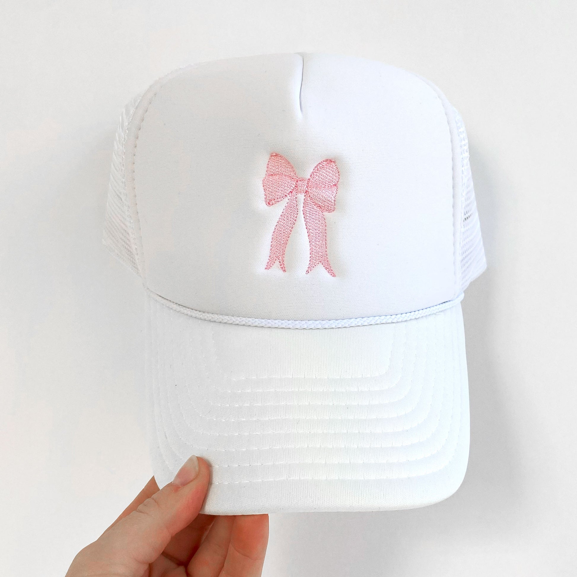White trucker hat with embroidered baby pink bow