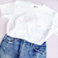 outfit layout featuring jeans and a white comfort colors tee with large outlined embroidered bow on the center