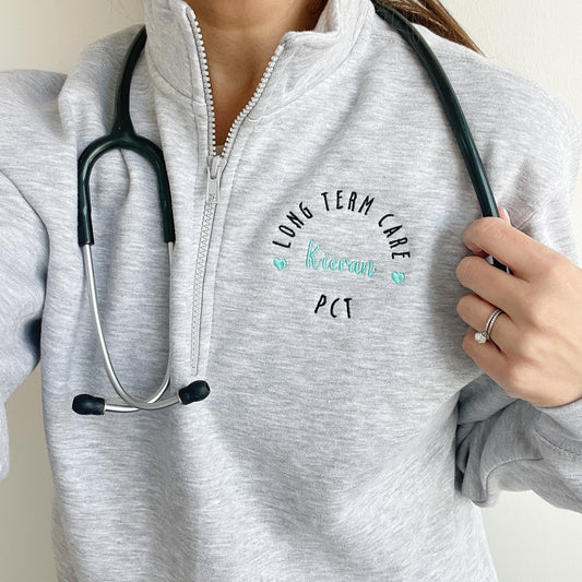 woman wearing a collared quarter zip with pockets featuring a round custom nurse embroidered design on the left chest