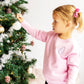 little girl hanging a christmas ornament wearing a light pink crewneck sweatshirt with a little debbie embroidery design on the left chest