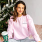 woman wearing a crewneck sweatshirt with a white little debbie tree and "oh christmas tree" embroidered on the left chest