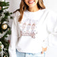  a woman wearing a white crewneck sweatshirt with a festive pastel nutcracker let's get crackin' design