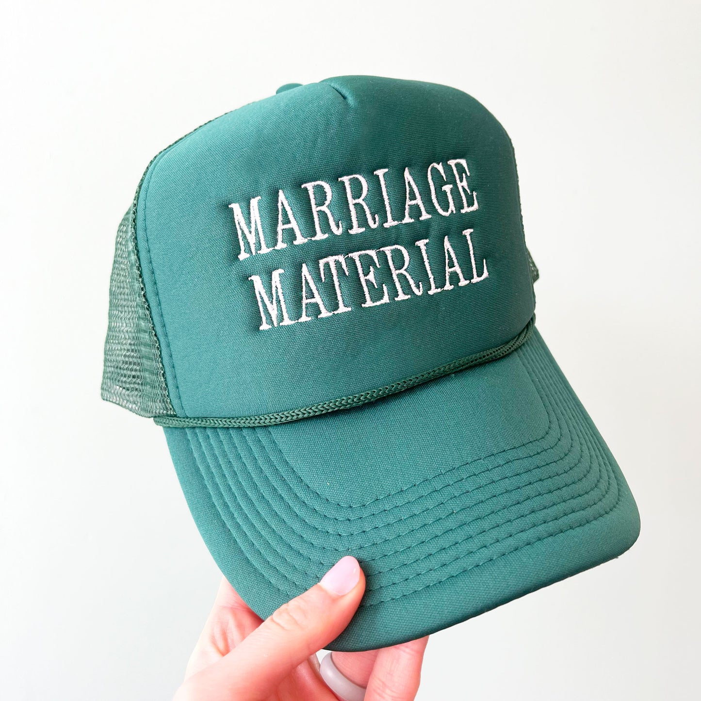 dark green trucker hat with embroidered allc aps marriage material in white thread