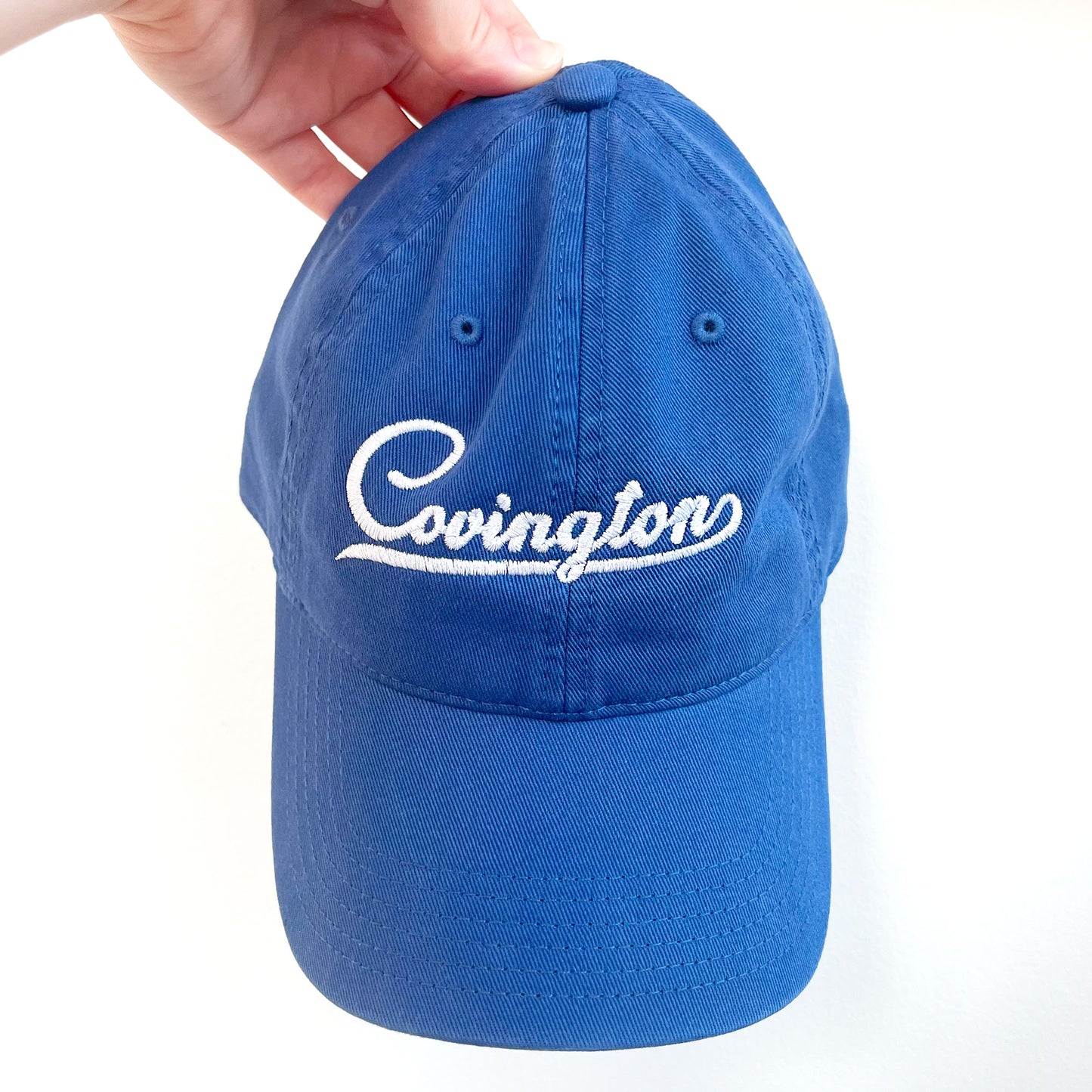 Royal Blue Embroidered baseball hat with Covington design in white thread