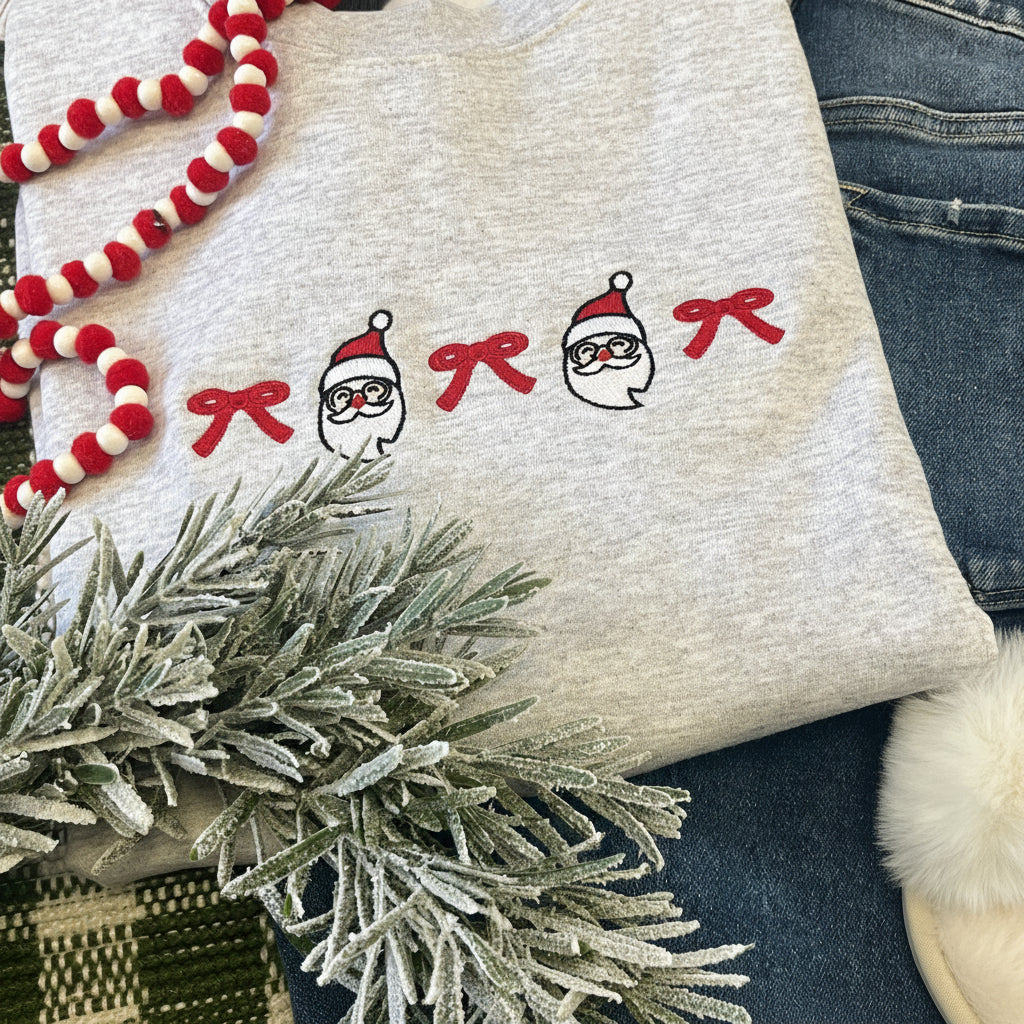 Gray sweatshirt with santa/bow embroidered designs paired with blue jeans