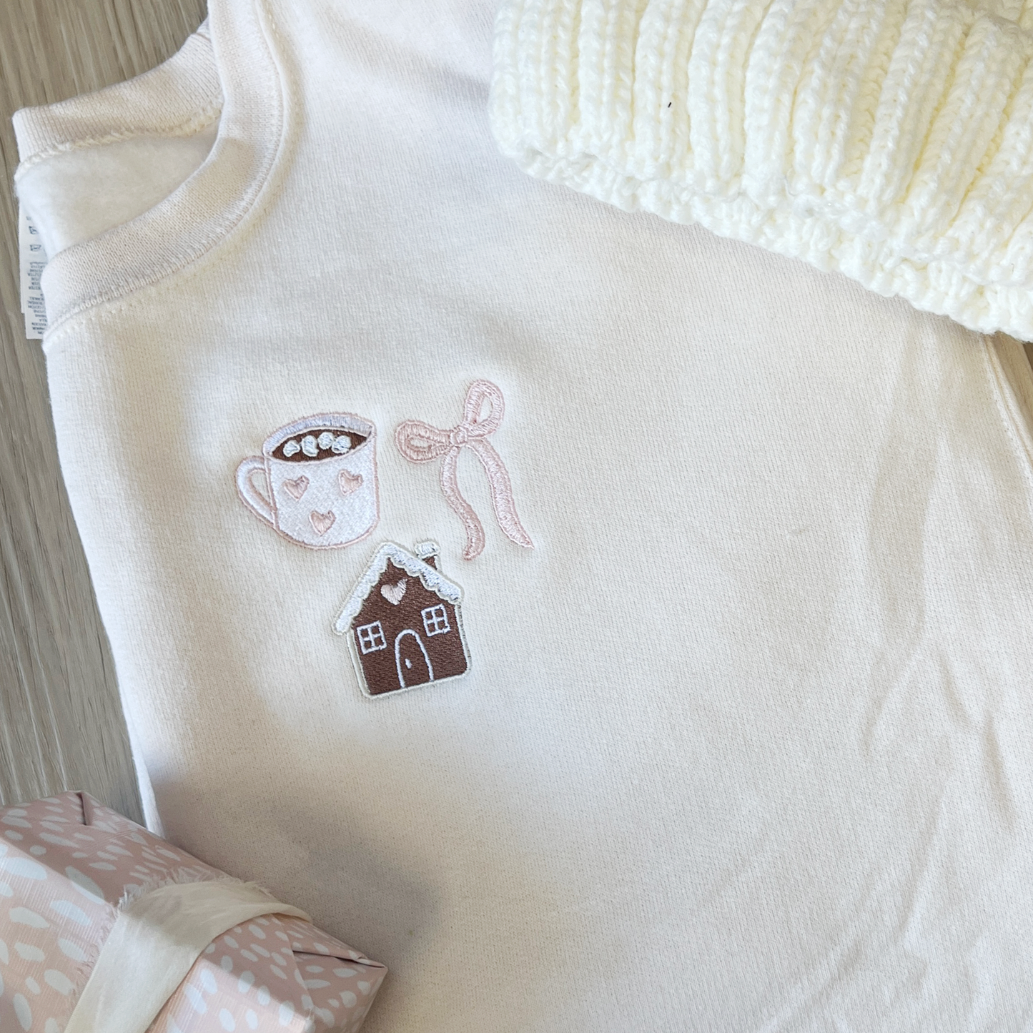 white crewneck with custom coquette gingerbread embroidery on the left chest