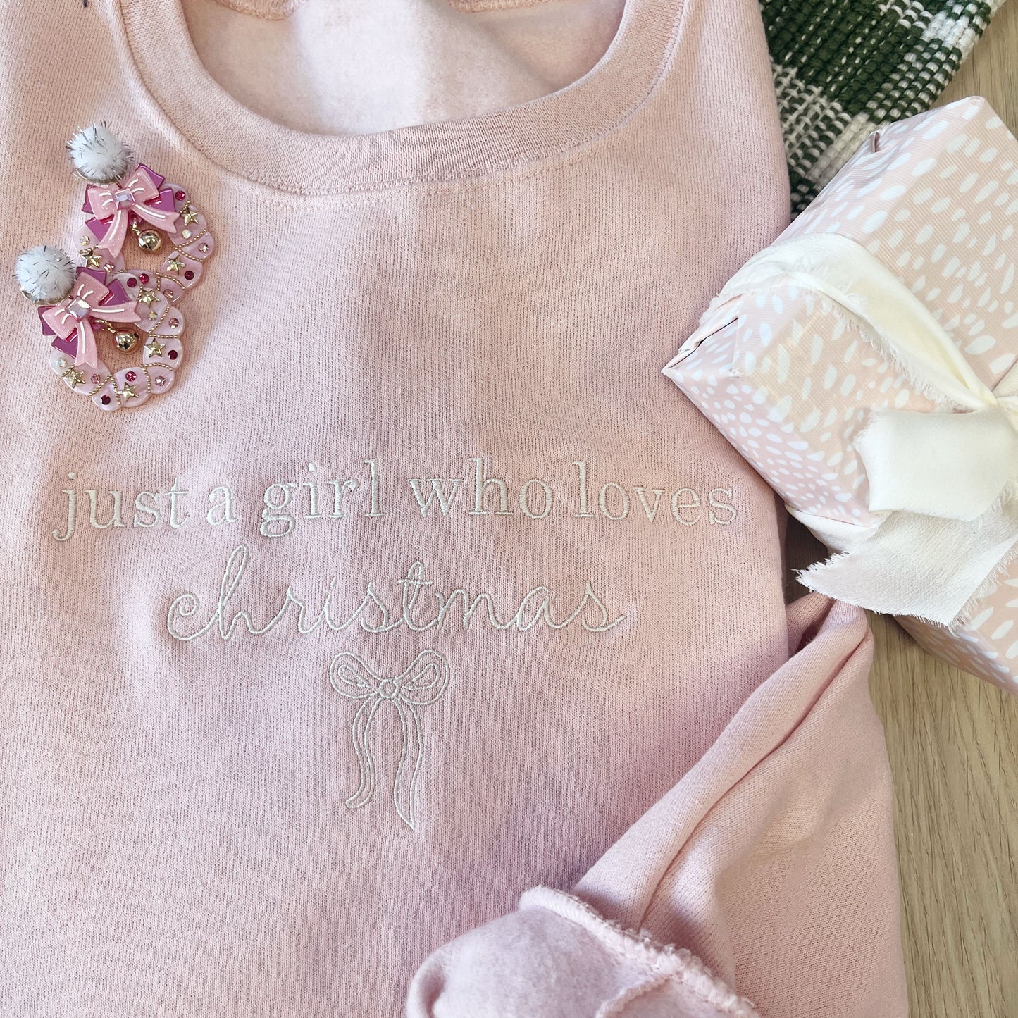 Pink garment with 'just a girl who loves Christmas' text and decorative elements.