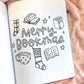 Open book with 'Merry Bookmas' text and festive illustrations on a soft fabric background