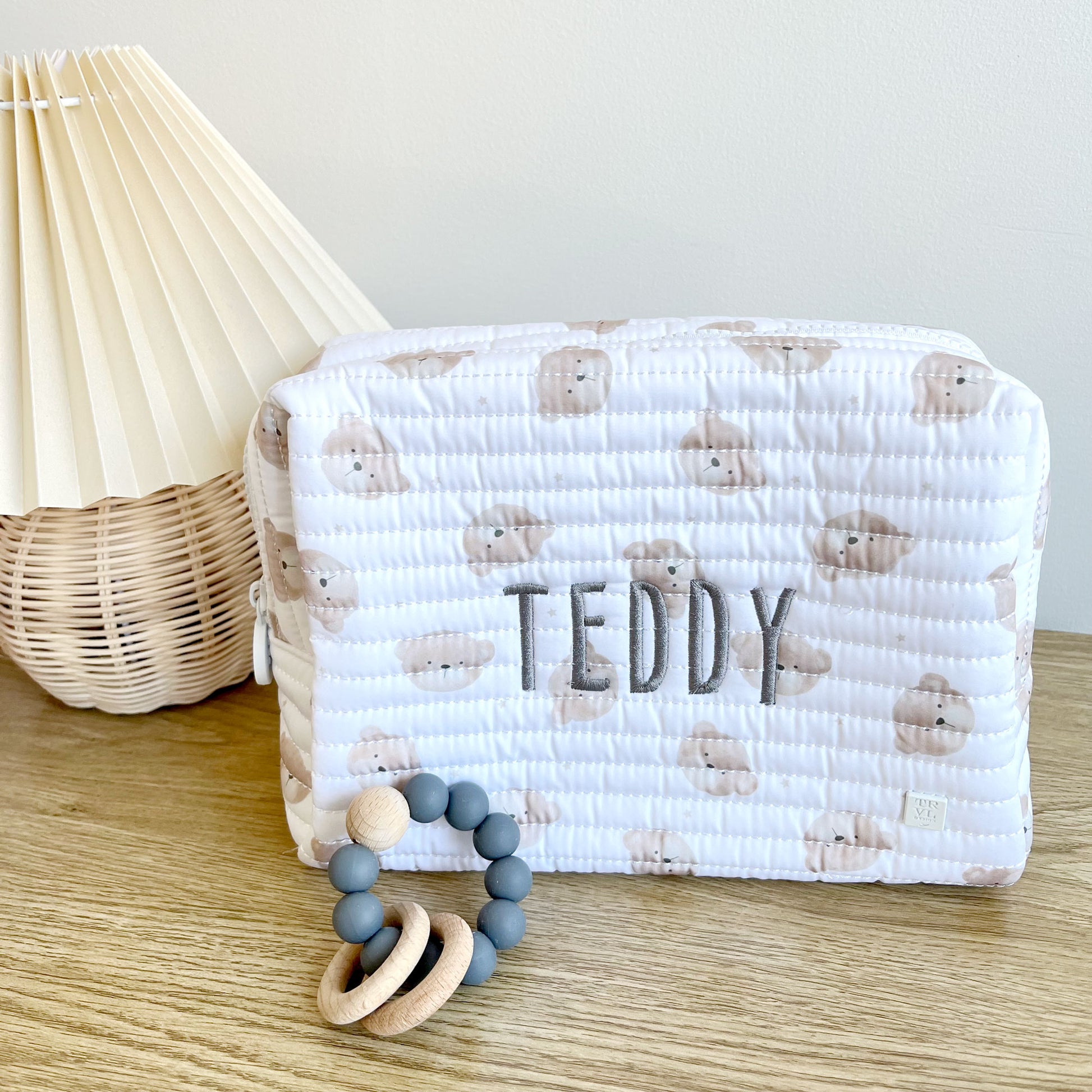 quilted children's everyday pouch with a teddy bear quilted fabric with gray thread name embroidery on the center
