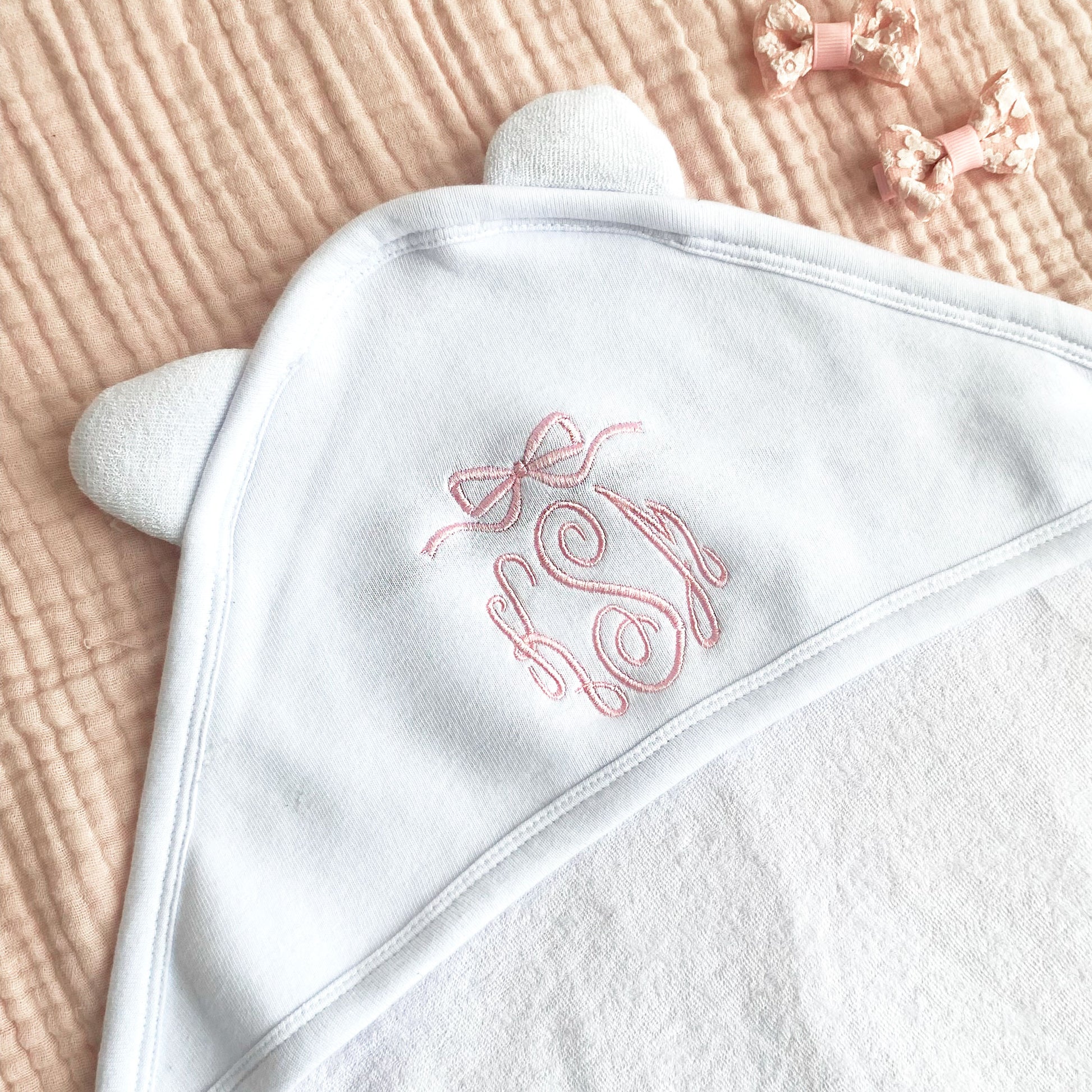Monogram and bow embroidered hooded baby towel on white with baby pink thread
