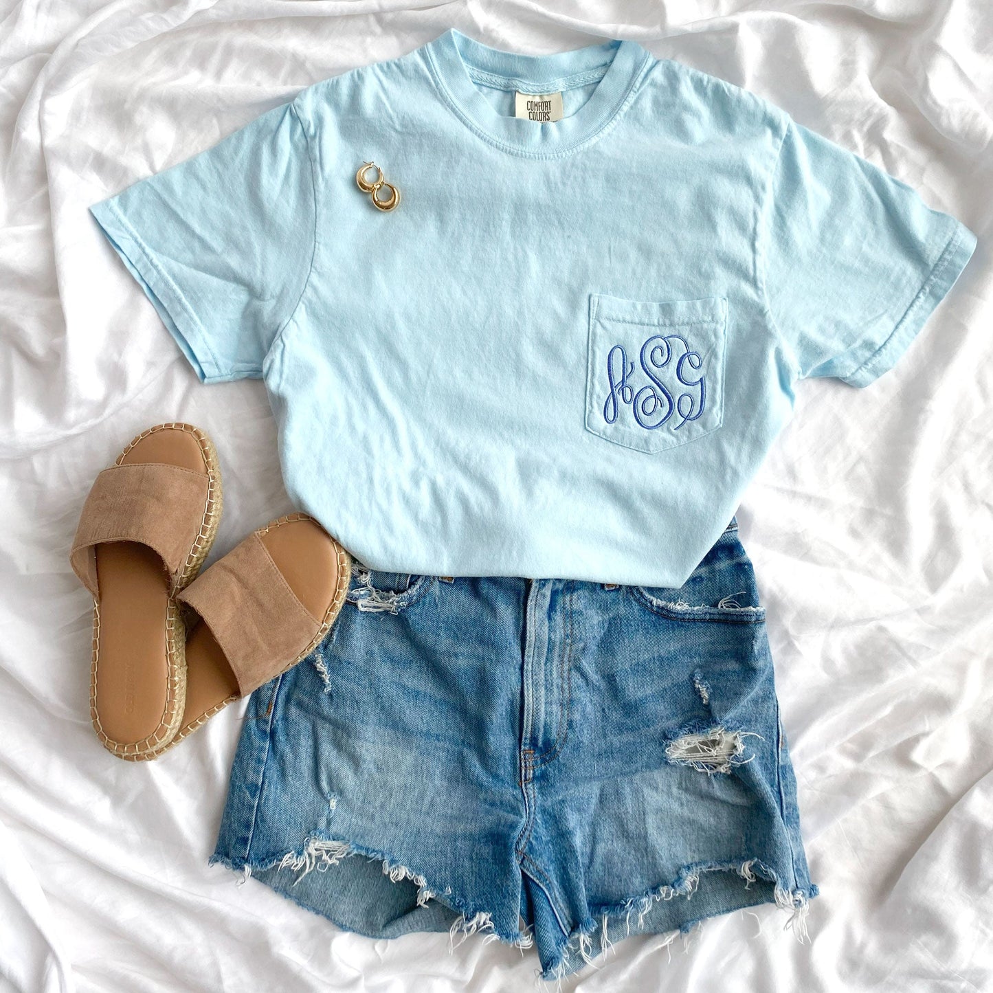styled outfit of chambray confort colors tee with monogram embroidered on the pocket with jeans and sneakers 