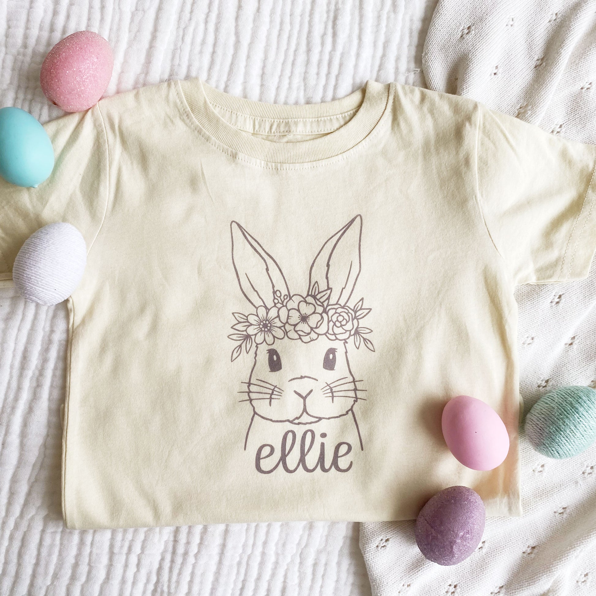 natural colored t-shirt with a bunny with a flower crown and personalized name printed on the front