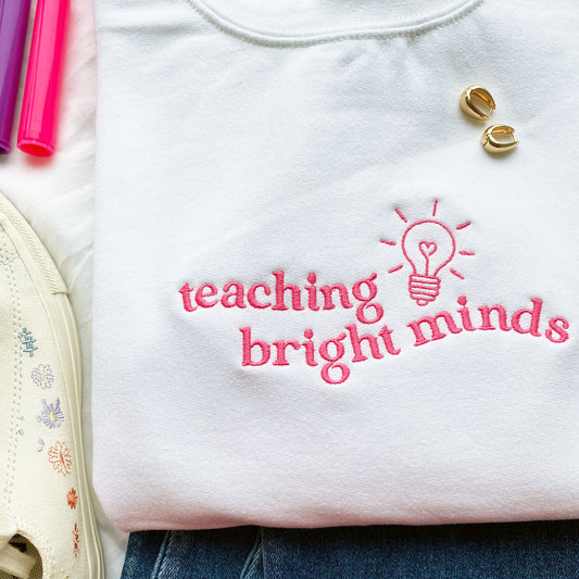 close up of cute teaching bright minds embroidered design on a sweatshirt