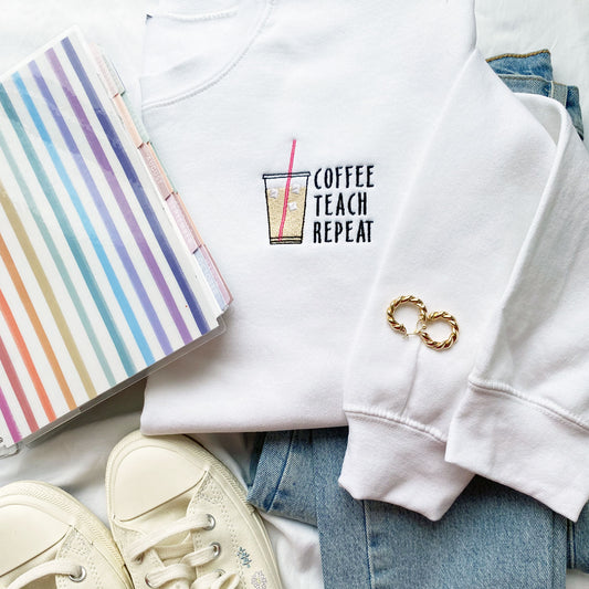 white sweatshirt with custom coffee teach repeat and iced coffee design on the left chest
