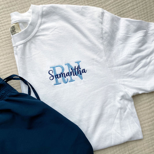 white comfort colors tee with a custom nurse embroidered design featuring credentials and name