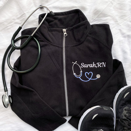 black jacket with nurse name, credential and heart stethoscope embroidery on the left chest
