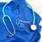 close up of a royal blue full zip polyester nurse jacket with custom embroidered heart stethoscope and name in white and sky thread! 
