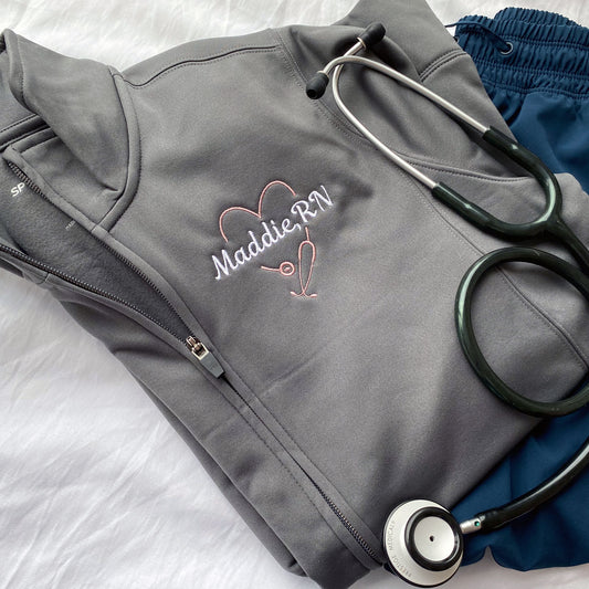 grey full zip jacket with a heart stethoscope and name embroidered design on the left chest