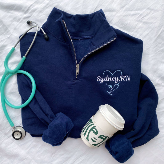 navy blue pullover quarter zip with custom nurse heart stethoscope design featuring name and credential embroidery
