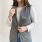 young woman modeling a grey fleece nurse vest with personalized RN design on the left chest