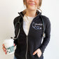 girl wearing a black fleece full zip jacket with personalized name, credential, and heart stethoscope embroidered design on the left chest