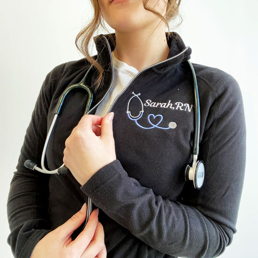 nurse wearing black fleece jacket with custom stethoscope and name embroidery on the left chest